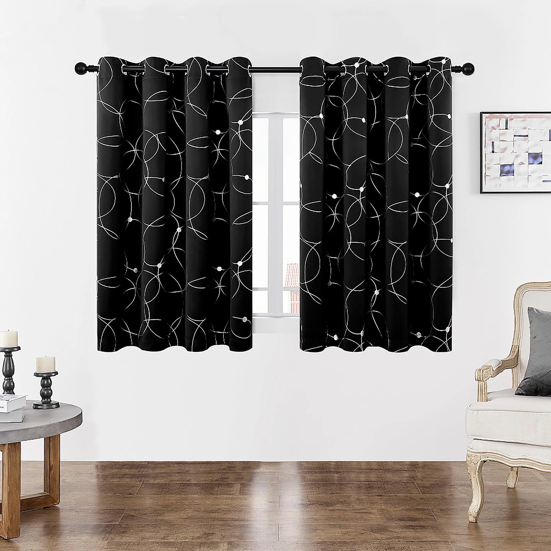 Gros plan sur la finition haute d’un rideau noir à motifs géométriques blancs avec œillets.