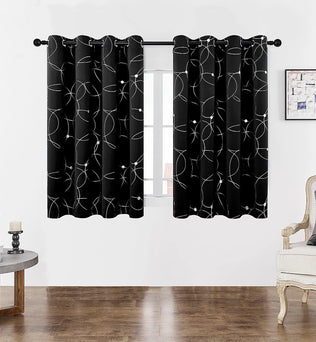 Gros plan sur la finition haute d’un rideau noir à motifs géométriques blancs avec œillets.