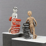figurines decoratives modernes personnages lisant livres piles livres beige blanc orange minimaliste