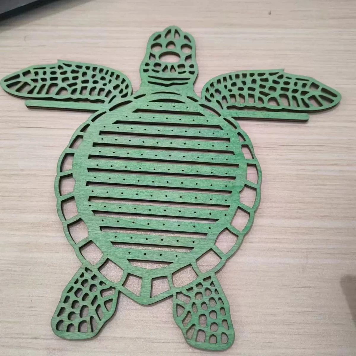 porte bijoux tortue verte bois clair ajouré motifs horizontaux naturel marin suspendu