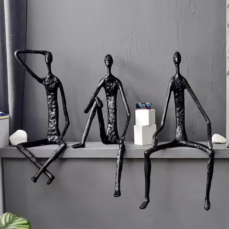 statues modernes minimalistes figures humaines assises noir texture brut forge lunettes livresintérieur