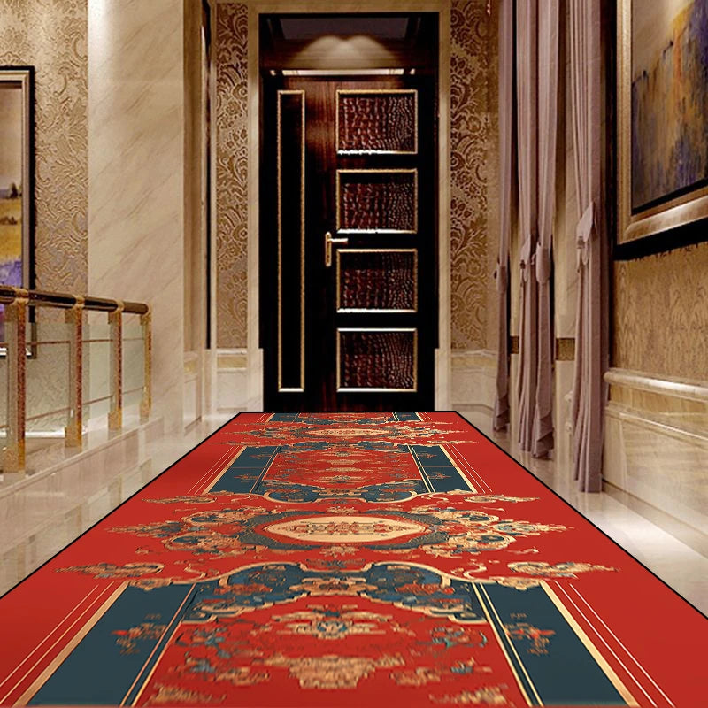 Couloir luxueux avec un magnifique tapis rouge orné de motifs floraux et ethniques, encadrant une porte en bois sombre à l'entrée.