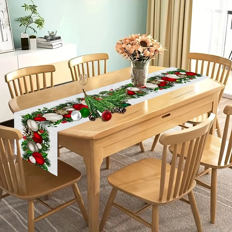 La table de salle à manger en bois avec un centre-de-table de Noël décoré de guirlandes de feuillage, de boules de Noël rouges et blanches, et d'un vase avec un bouquet de fleurs dans un intérieur moderne et lumineux.