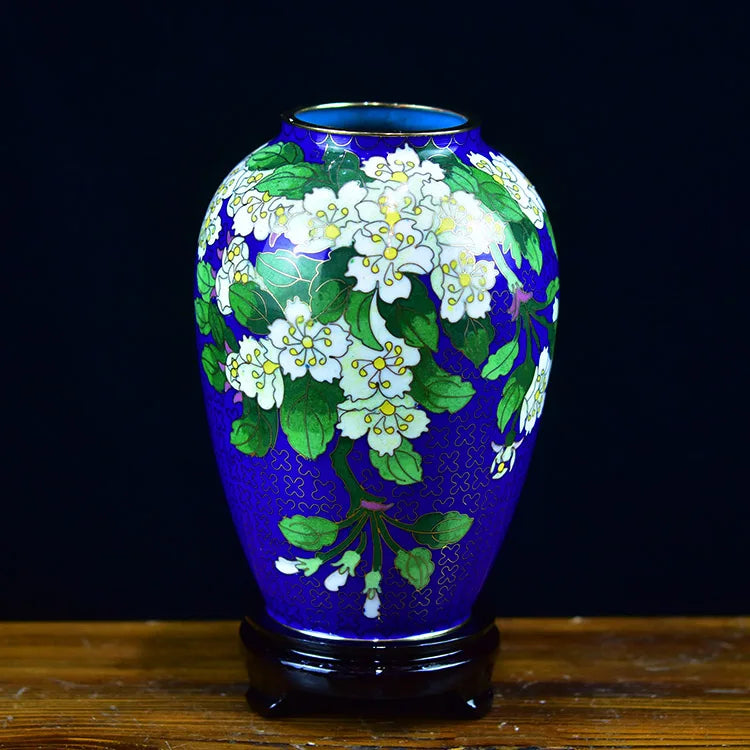 Vase bleu et vert avec des fleurs blanches, créé avec des motifs élégants et un style artistique.