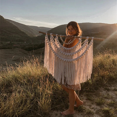 Tenture murale en macramé boho suspendue au-dessus d'un lit