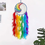 Dreamcatcher multicolore décoratif suspendu avec des plumes arc-en-ciel et un cerceau en forme de lune.
