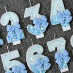 bougies anniversaire chiffres paillettes bleues rubans décoratives festives numérotées blanc