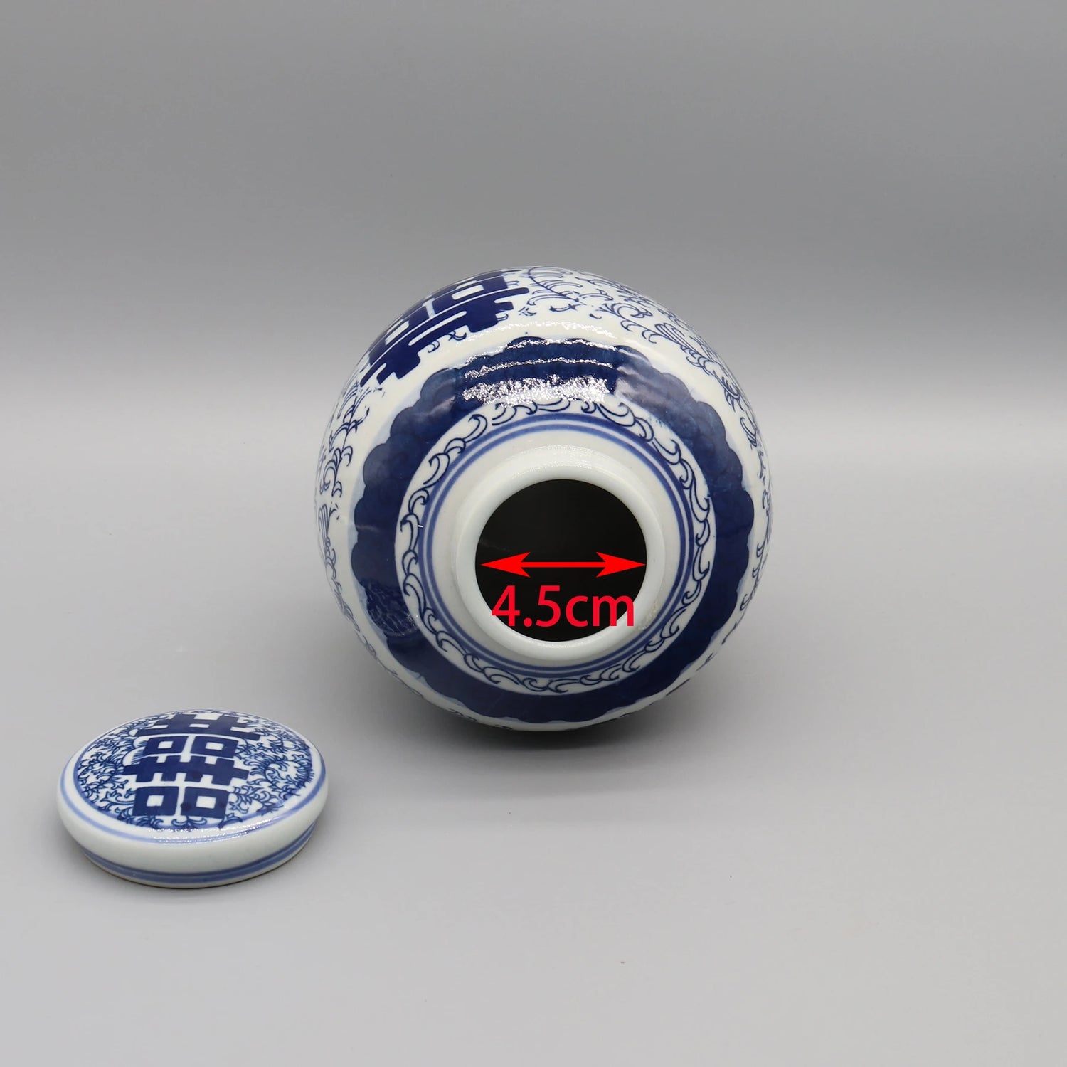 Boule de porcelaine décorée de motifs bleu et blanc, avec une mesure de 4,5 cm visible sur l'image.