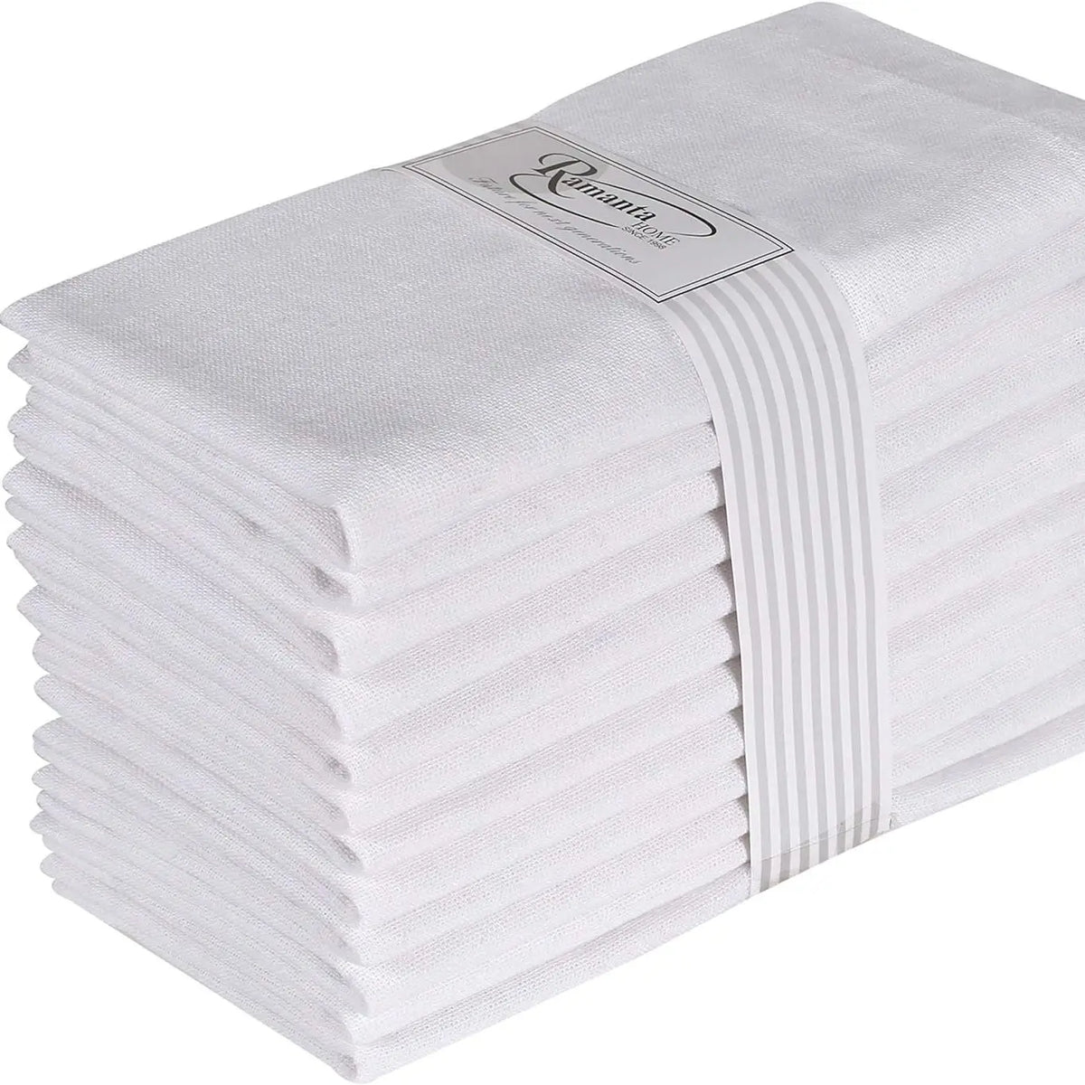 Une pile de serviettes en coton blanc, attachées par un ruban blanc, représentant une collection de linge de maison élégante et durable.
