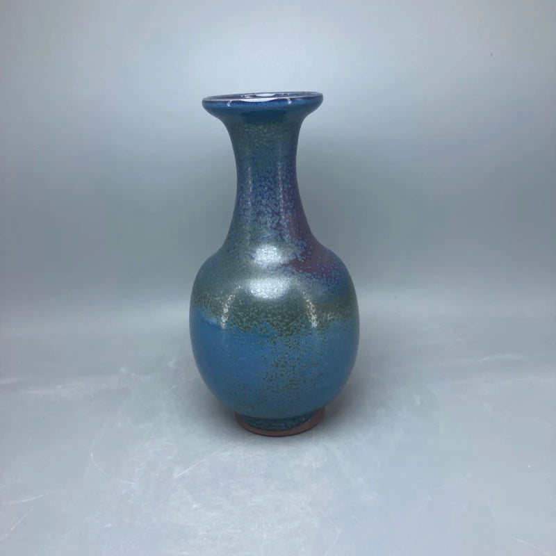 Vase en céramique émaillé bleu et vert avec un motif irisé, présentant une forme galbée et un col étroit.