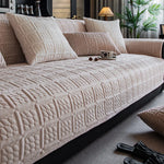 Un canapé d'angle confortable et élégant avec des coussins beiges et un design texturé, créant une ambiance chaleureuse et accueillante dans ce salon.