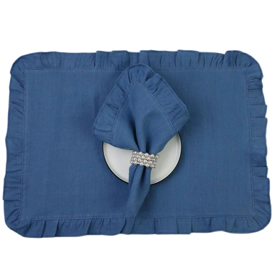 Nappe bleue avec nœud et anneau de serviette strass sur un plat blanc.