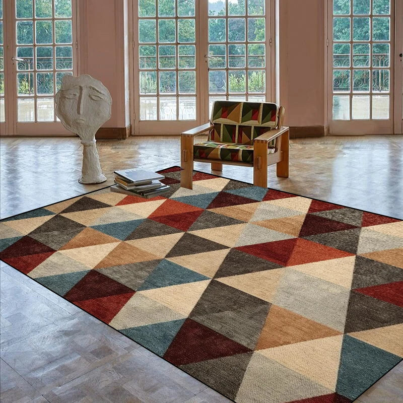 L'image montre un grand tapis coloré et géométrique dans une pièce ensoleillée avec de hautes fenêtres, une sculpture en plâtre, et un fauteuil décoratif.