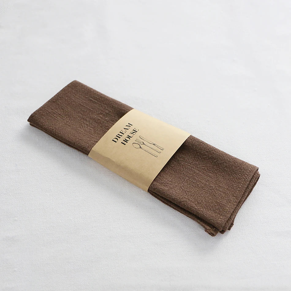 serviettes tissu pliées rustique bohème minimaliste liens anneaux couleurs beige rose vert bleu gris