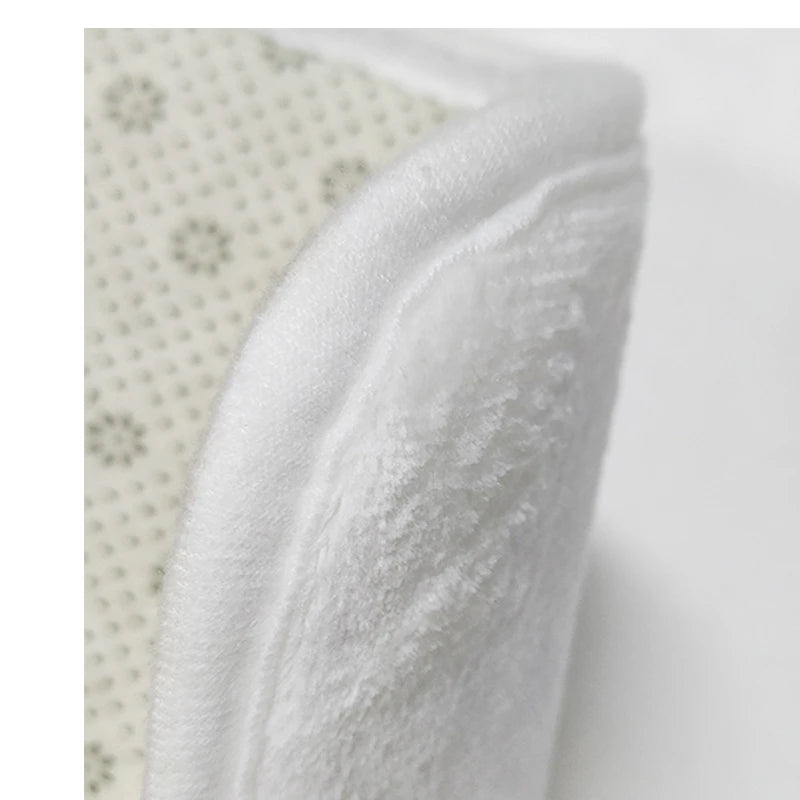 Cette image montre un gros plan détaillé d'un tissu blanc doux et moelleux orné de petits motifs.
