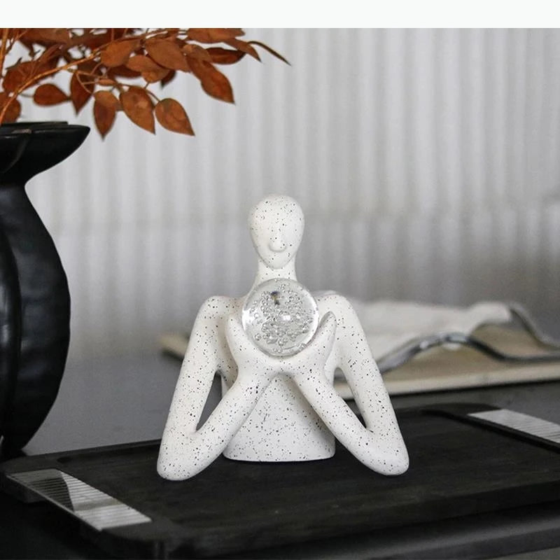 statue décorative personnage humain sphère transparente motifs internes neige cristaux blanc taches noires.texture granuleuse