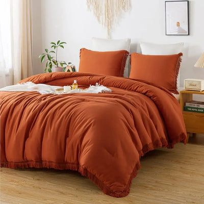 Parure de lit king size orange brûlé avec pompons boho sur un lit