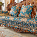 Le canapé en bois sculpté, recouvert d'un tissu fleuri bleu et doré, est un élément décoratif élégant et luxueux qui ajoute de la richesse et de la sophistication à cette pièce.