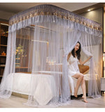 Une femme est assise sur un lit vêtue d'une robe blanche dans une chambre meublée avec un bel lit à baldaquin.