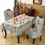 Une pièce accueillante avec une table recouverte d'une nappe fleurie et des chaises assorties, créant une ambiance chaleureuse et élégante.