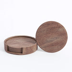 Ensemble de sous-verres en bois rond de couleur marron foncé avec un motif de grain de bois visible, présentés empilés les uns sur les autres.