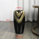 Vase décoratif en forme de vase de fleurs avec motifs abstraits noirs et beiges, mesurant 41 cm de hauteur et 15 cm de diamètre.