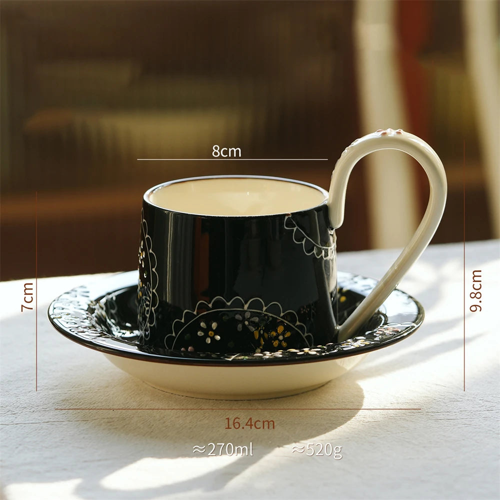 Une tasse de café ou de thé élégante et ornée, avec sa soucoupe, sur une surface blanche.