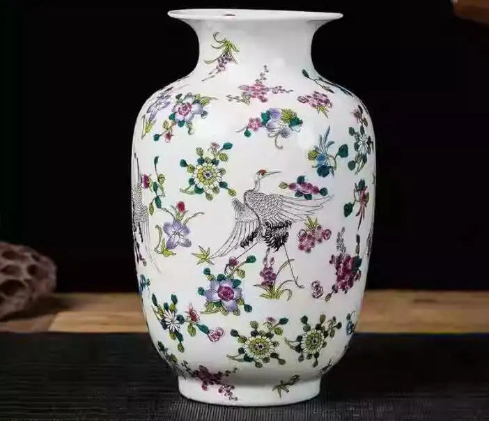 Un vase en porcelaine blanche orné de motifs floraux et d'un oiseau décoratif, créant une scène de beauté et d'élégance.