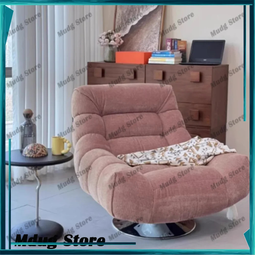 fauteuil pivotant moderne rose velours côtelé intérieur coussin décoratif livres vase fleurs