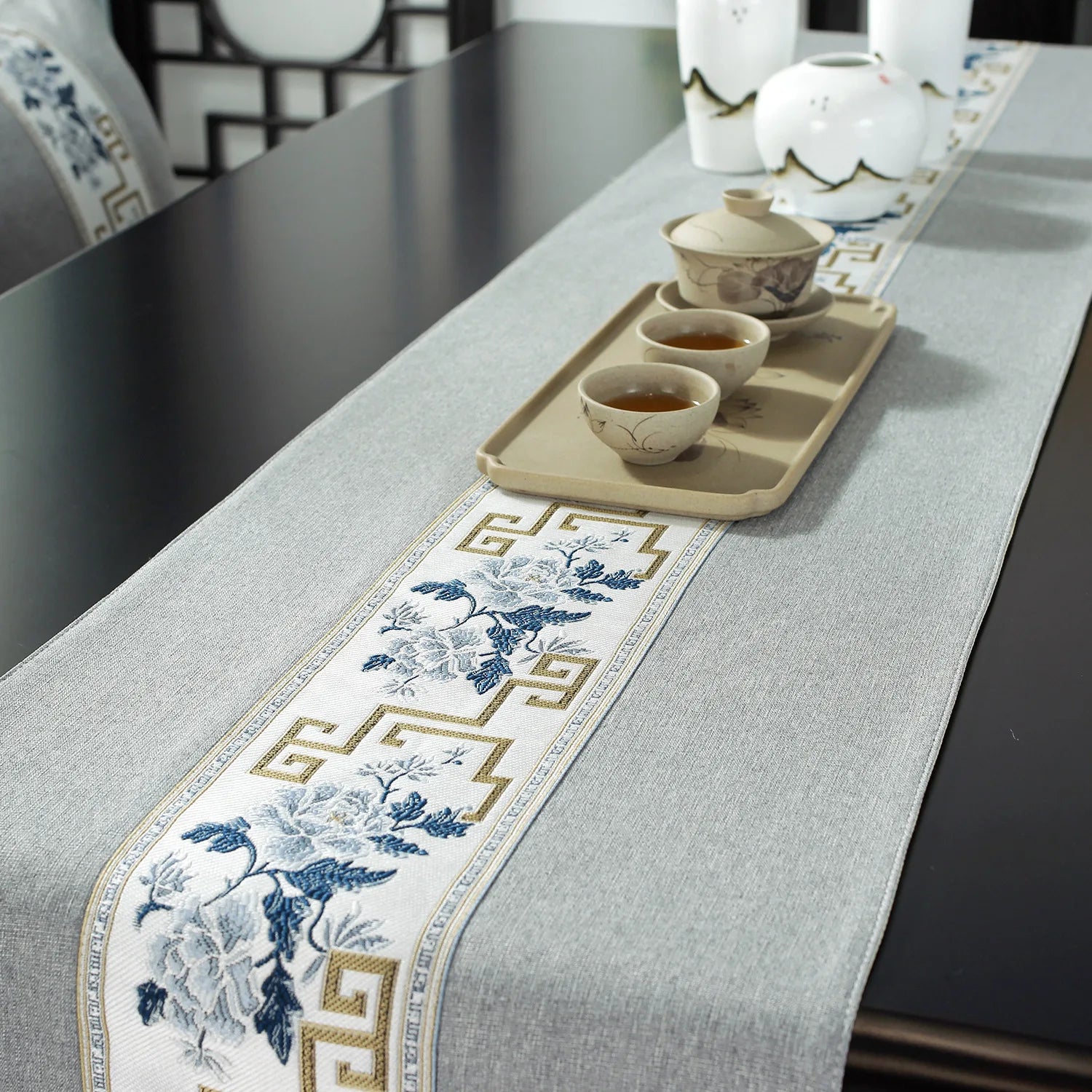 Composition raffinée mettant en scène un service à thé traditionnel sur un plateau de bois orné de motifs floraux bleus et dorés, créant une atmosphère élégante et apaisante.