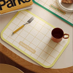 tapis table moderne rectangle blanc bleu vert rouge grille bordure colorée assiette cuillère tasse