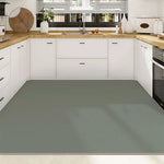 Une cuisine contemporaine épurée avec des armoires blanches, un plan de travail en bois clair et un sol en linoléum gris.