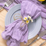 Une table de fête élégante avec une nappe violette et une décoration florale sur une assiette grise.