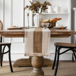 Table de salle à manger rustique avec décorations florales, vaisselle et accessoires de cuisine, créant une ambiance chaleureuse et élégante.