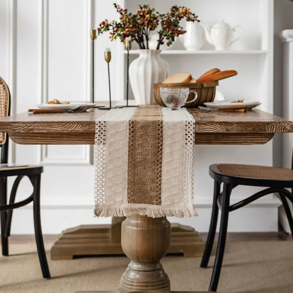 Table de salle à manger rustique avec décorations florales, vaisselle et accessoires de cuisine, créant une ambiance chaleureuse et élégante.