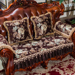 Un canapé en cuir brun richement décoré de coussins et de nappes à motifs floraux, créant une atmosphère luxueuse et élégante dans une pièce.