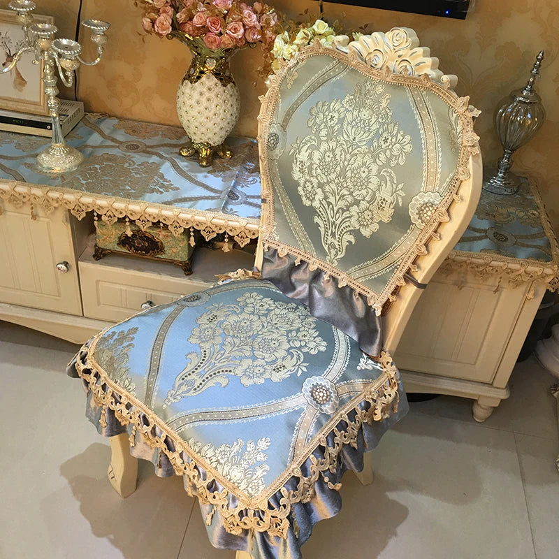 Fauteuil vintage orné de motifs floraux et de dentelle dorée, positionné dans un élégant intérieur aux teintes pastel.