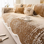 Un canapé confortable et douillet, orné de coussins et d'un plaid moelleux, offrant une ambiance cocooning et chaleureuse dans cette pièce lumineuse.