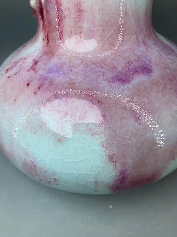 Vase en céramique de forme unique avec des motifs abstraits de couleurs pastel et d'éclats de verre.
