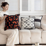 Un arrangement harmonieux de coussins décoratifs aux motifs floraux et géométriques, créant une ambiance chaleureuse et accueillante dans l'espace.