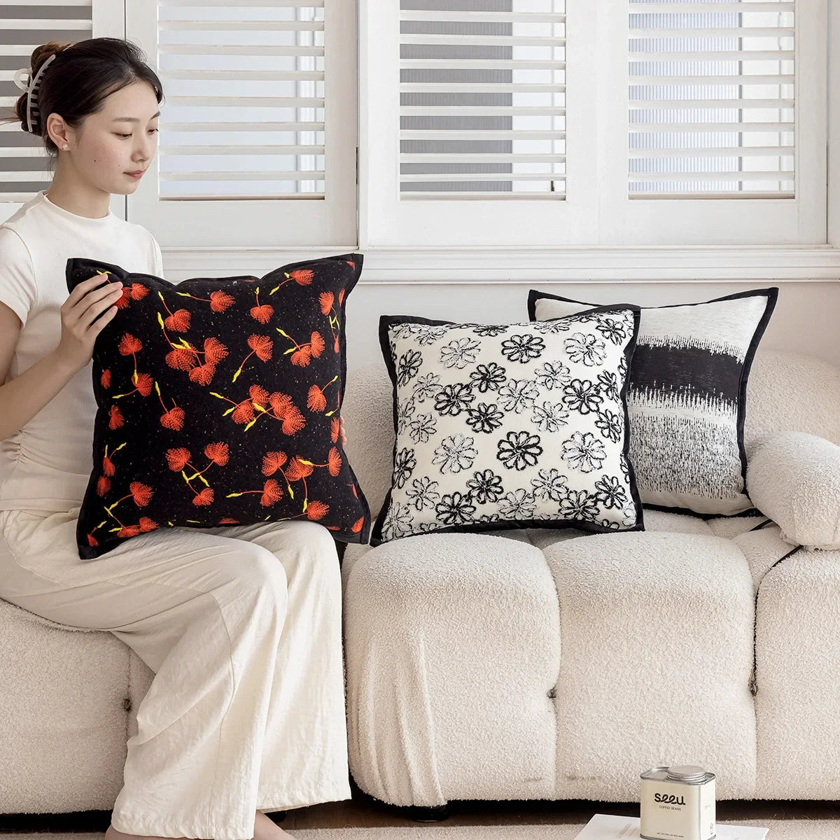 Un arrangement harmonieux de coussins décoratifs aux motifs floraux et géométriques, créant une ambiance chaleureuse et accueillante dans l'espace.