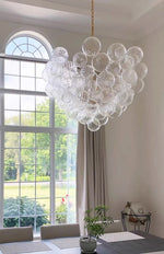 suspension lumineuse moderne verre transparent chaîne dorée led acier poli contemporain lumière chaude chambre