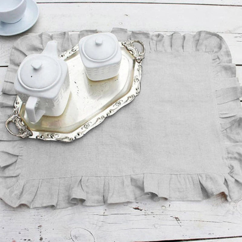 Composition de service à thé blanc avec pot, tasses et plateau en céramique sur un fond rustique en bois clair.
