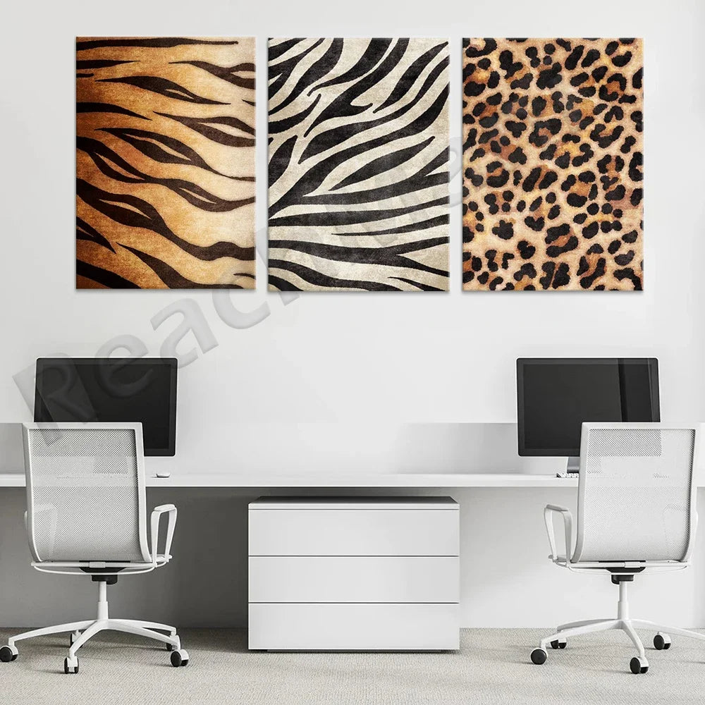 Ensemble de trois imprimés décoratifs aux motifs de fourrure d'animal, composé de rayures de zèbre, de tigre et de léopard, sur un mur blanc dans un bureau avec deux chaises de bureau blanches et un meuble de rangement.