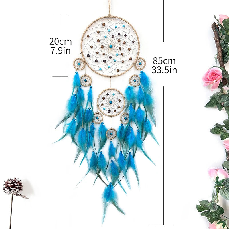 Un grand attrape-rêves bleu et beige décoré de plumes et de perles, suspendu par une corde.