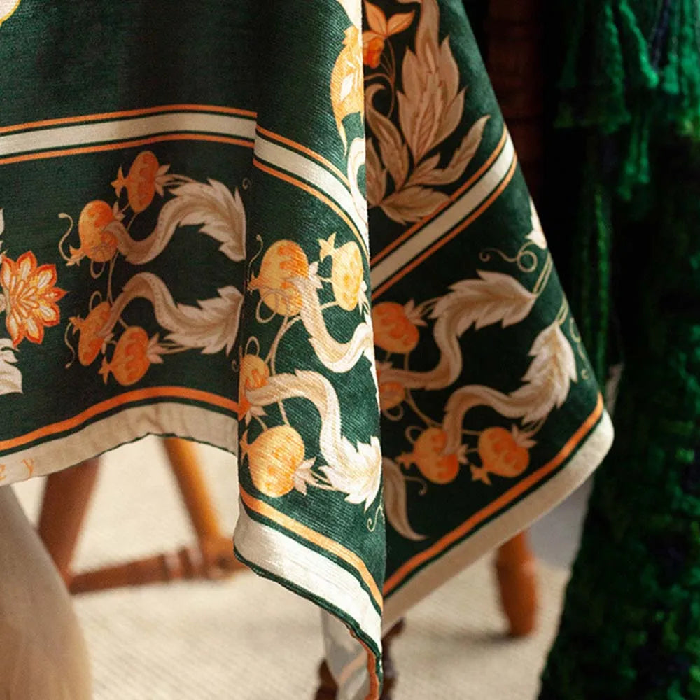 Une robe longue aux motifs floraux complexes et élégants dans des tons de vert et d'orange.