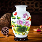 Un vase en porcelaine blanche orné de magnifiques fleurs de lotus roses épanouies sur un fond vert verdoyant.