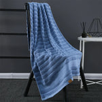 Une élégante couverture en velours bleu rayé, parfaite pour se réchauffer et apporter une touche de confort et de style à votre intérieur.