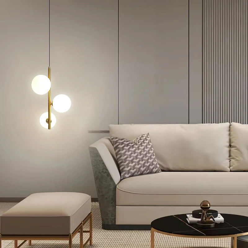 suspension lumineuse moderne sphères translucides barre métallique brillante blanc doré minimaliste chambre salon
