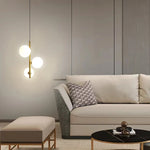 suspension lumineuse moderne sphères translucides barre métallique brillante blanc doré minimaliste chambre salon